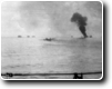 A Japanese torpedo bomber hit as it skims by.